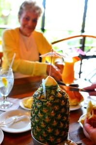 My grandmother in the background, but your focus should be on the INCREDIBLY TASTY DRINK IN AN ACTUAL PINEAPPLE.